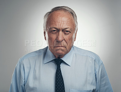 Buy stock photo Shot of a senior businessman standing alone against a grey background in the studio and looking frustrated