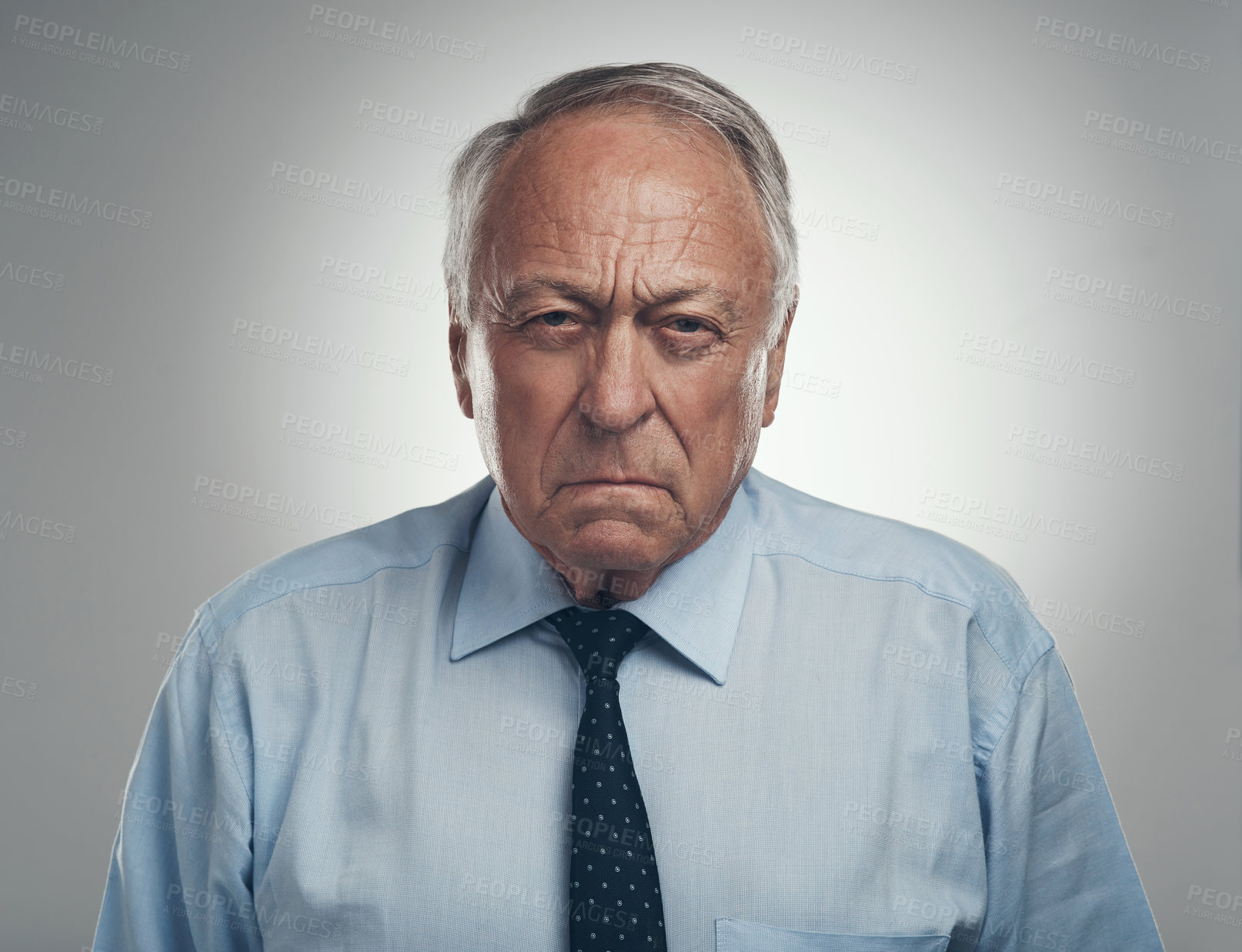 Buy stock photo Shot of a senior businessman standing alone against a grey background in the studio and looking frustrated