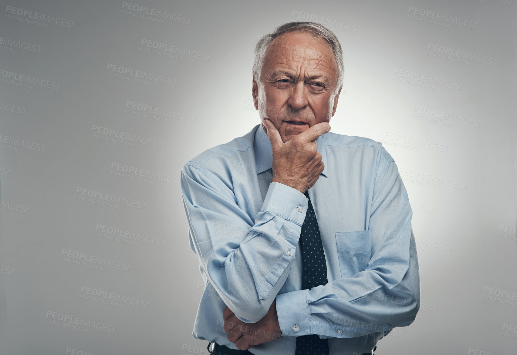 Buy stock photo Shot of a senior businessman standing alone against a grey background in the studio and looking contemplative
