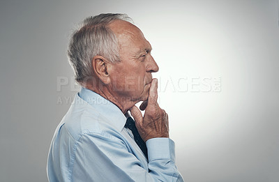 Buy stock photo Shot of a senior businessman standing alone against a grey background in the studio and  looking contemplative
