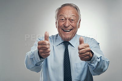 Buy stock photo Shot of a senior businessman standing alone against a grey background in the studio with his thumbs up