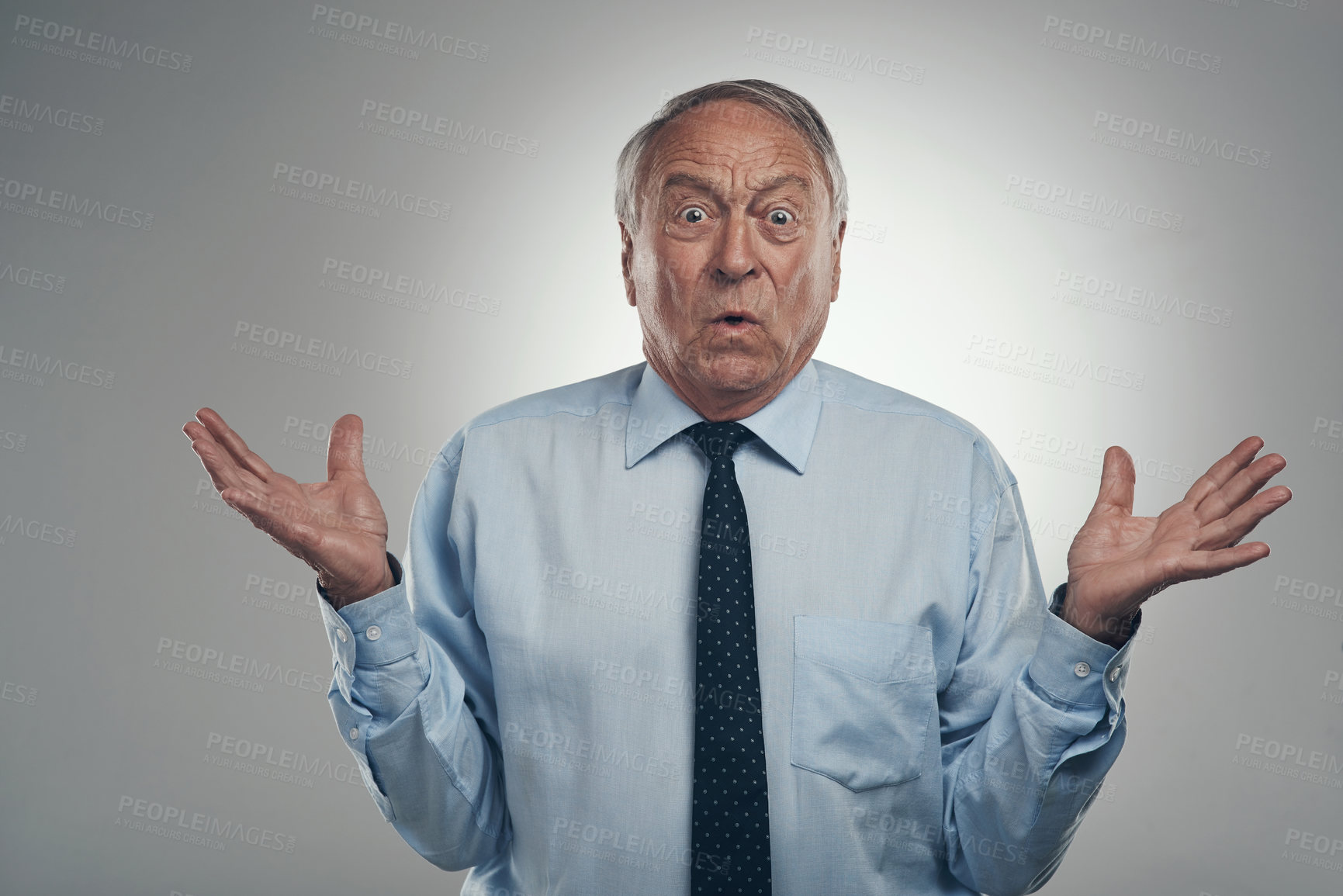 Buy stock photo Shot of a senior businessman standing alone against a grey background in the studio and looking confused