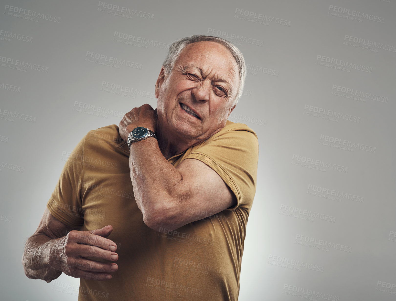Buy stock photo Studio shot of an elderly man experiencing some pain against a grey background