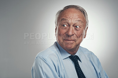 Buy stock photo Shot of a senior businessman standing alone against a grey background in the studio and looking surprised