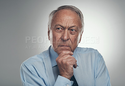 Buy stock photo Shot of a senior businessman standing alone against a grey background in the studio and looking contemplative