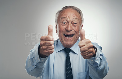 Buy stock photo Shot of a senior businessman standing alone against a grey background in the studio with his thumbs up