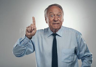 Buy stock photo Shot of a senior businessman standing alone against a grey background in the studio and gesturing