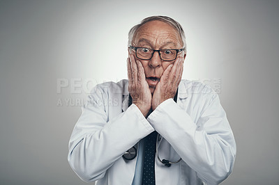 Buy stock photo Shot of an elderly male doctor in a studio against a grey background