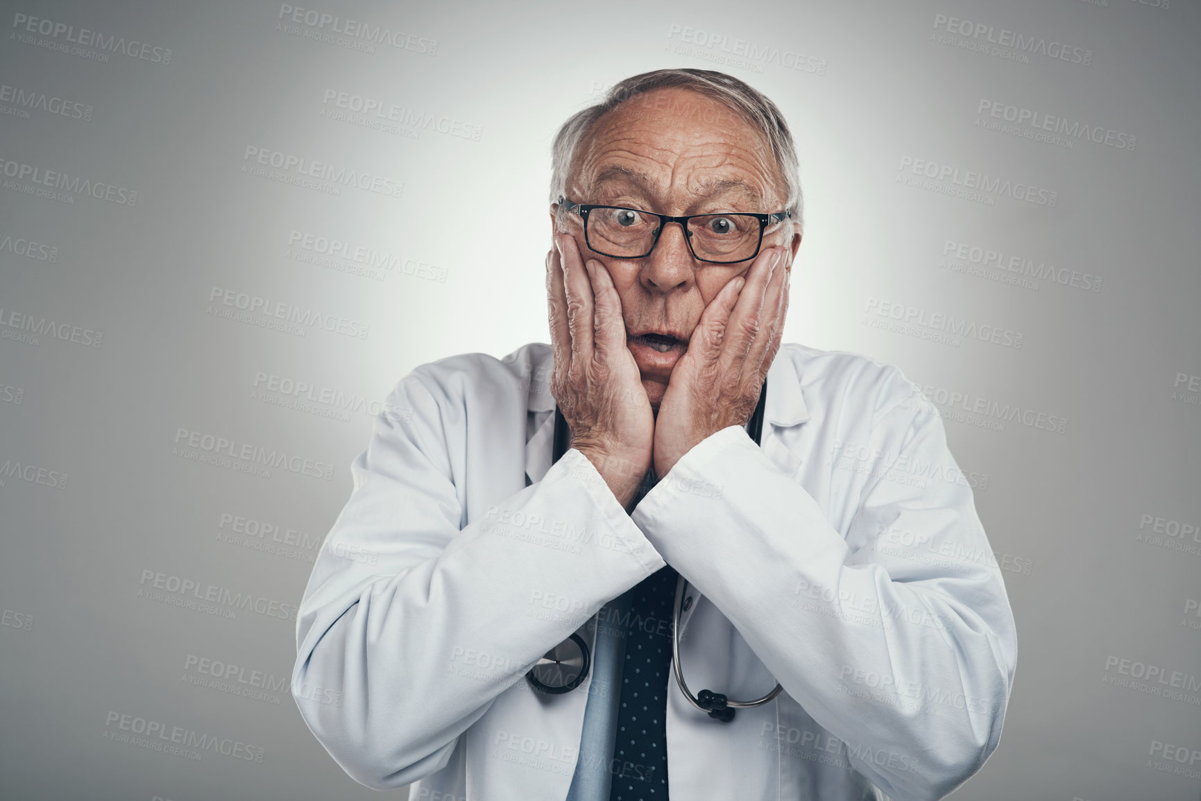 Buy stock photo Shot of an elderly male doctor in a studio against a grey background