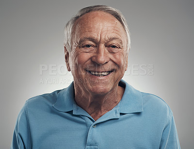 Buy stock photo Shot of a man happily smiling at the camera in a studio against a grey background