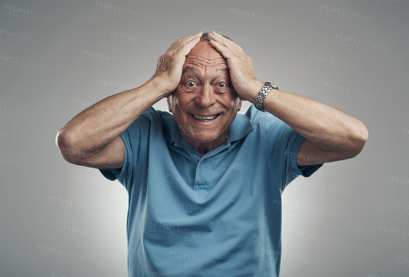 Buy stock photo Shot of an older man with his hands on his head in shock in a studio against a grey background