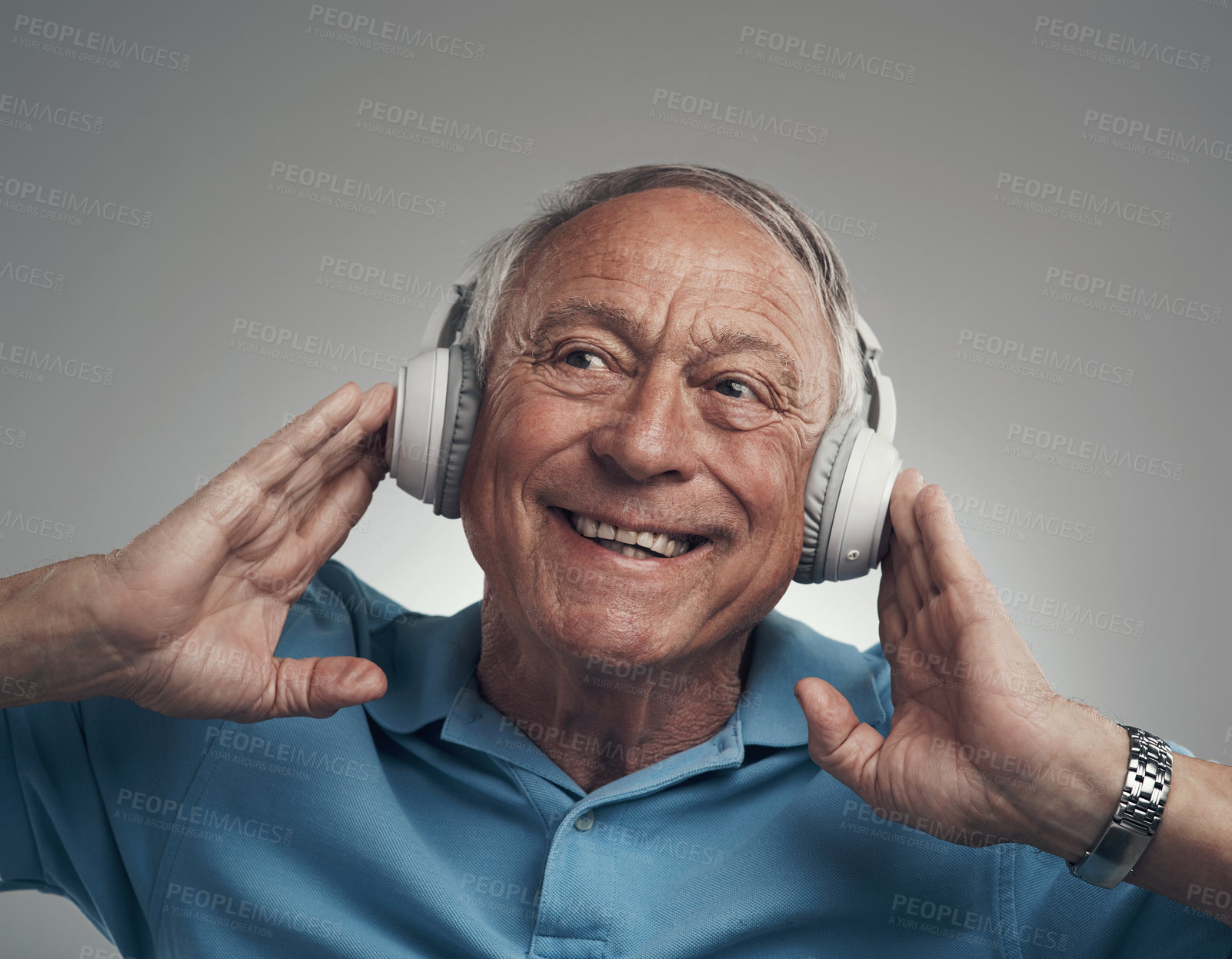 Buy stock photo Shot of an elderly male wearing headphones and listening to music in a studio against a grey background