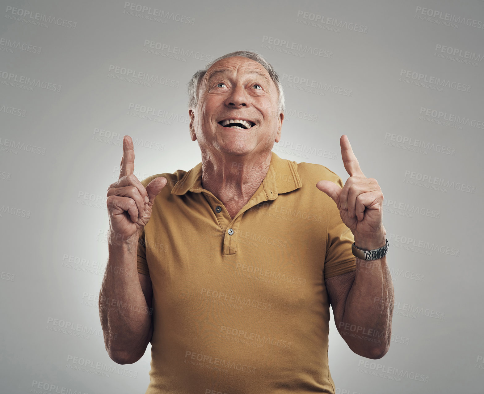 Buy stock photo Studio shot of an elderly man pointing in at something and smiling against a grey background