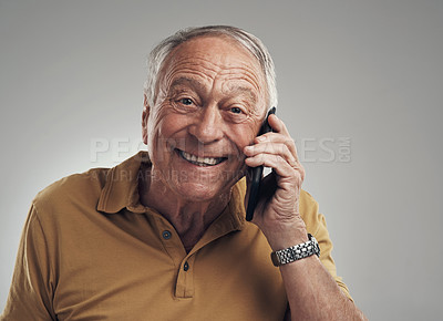 Buy stock photo Studio shot of an elderly man using his cellphone against a grey background