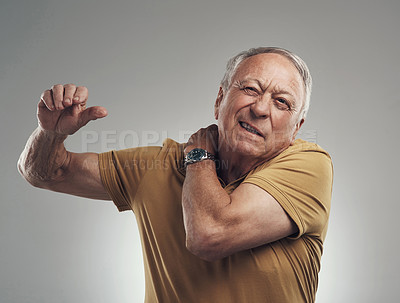 Buy stock photo Studio shot of an elderly man experiencing some pain against a grey background