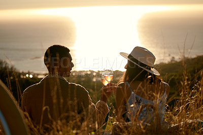Buy stock photo Shot of a young couple enjoying the sunset outside in nature