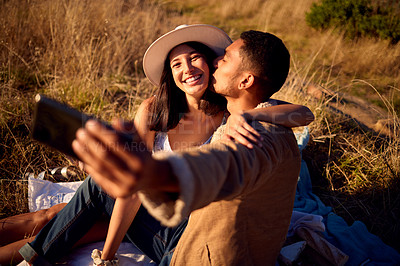 Buy stock photo Couple kiss in selfie with hug, outdoor and picnic in nature, love with smartphone, technology and happy together. Phone for photography, man and woman smile in picture with travel and summer date