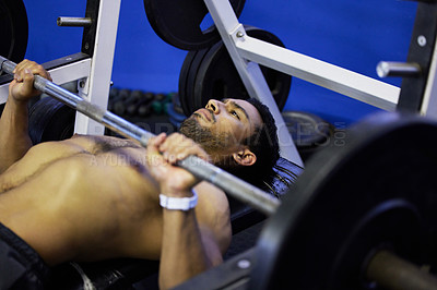 Buy stock photo Shot of a young man doing press ups during his workout routine at the gym