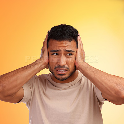 Buy stock photo Scared, loud and man worried by his stress and covering his ears in fear of noise isolated against a studio orange background. Young, hispanic or guy frustrated by sound causing head pain or ache