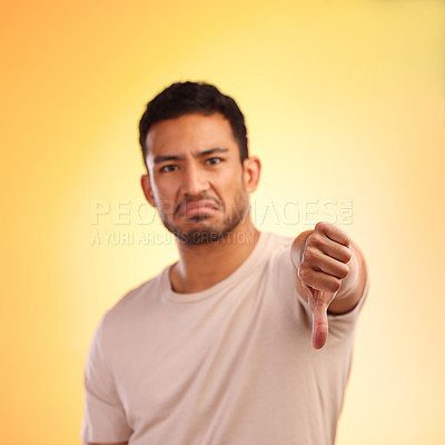 Buy stock photo Man, thumbs down and studio portrait with sad, depressed face and frustrated by yellow studio background. Young model, depression or hand sign for emotion, communication and mental health problem