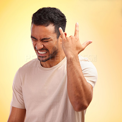 Buy stock photo Happy, confident and Asian man with hand for rock isolated on a yellow studio background. Condidence, music and person with a gesture sign for fun, metal sound and audio on a bright backdrop