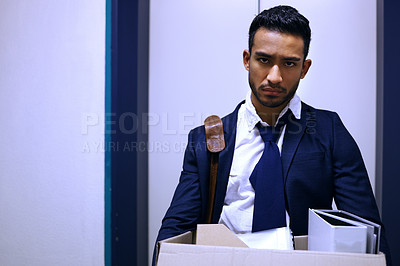 Buy stock photo Cropped shot of a handsome young businessman looking depressed after being retrenched from work