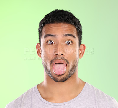 Buy stock photo Man, portrait and goofy in studio, tongue and silly comic or funny face on green background. Male person, mockup space and emoji for joke or comedy, student and humor for crazy character and quirky
