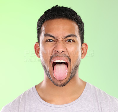 Buy stock photo Man, portrait and frown in studio, tongue and goofy comic or funny face on green background. Male person, mockup space and emoji for joke or comedy, student and humor for crazy character and quirky