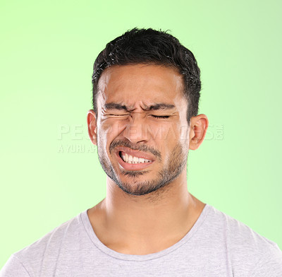 Buy stock photo Migraine, man and pain with hurt from headache with stress and anxiety in a studio. Brain fog, tension and mistake with casual fashion and modern style with problem and issue with green background