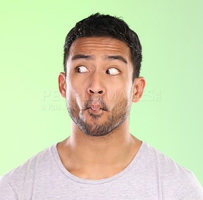 Buy stock photo Thinking, crazy and face of funny man in studio with pastel green background for weird comedy. Silly, joke and embarrassed person with doubt or confused by creative ideas in awkward mock up space
