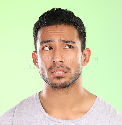 Buy stock photo Confused man, thinking and unsure with wonder in doubt, question or uncertainty on a green studio background. Face of male person or worried model in thought, ponder or curious for idea or decision