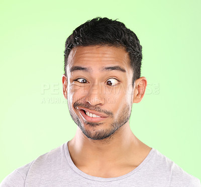 Buy stock photo Cropped shot of a handsome young man making a face against a green background in studio