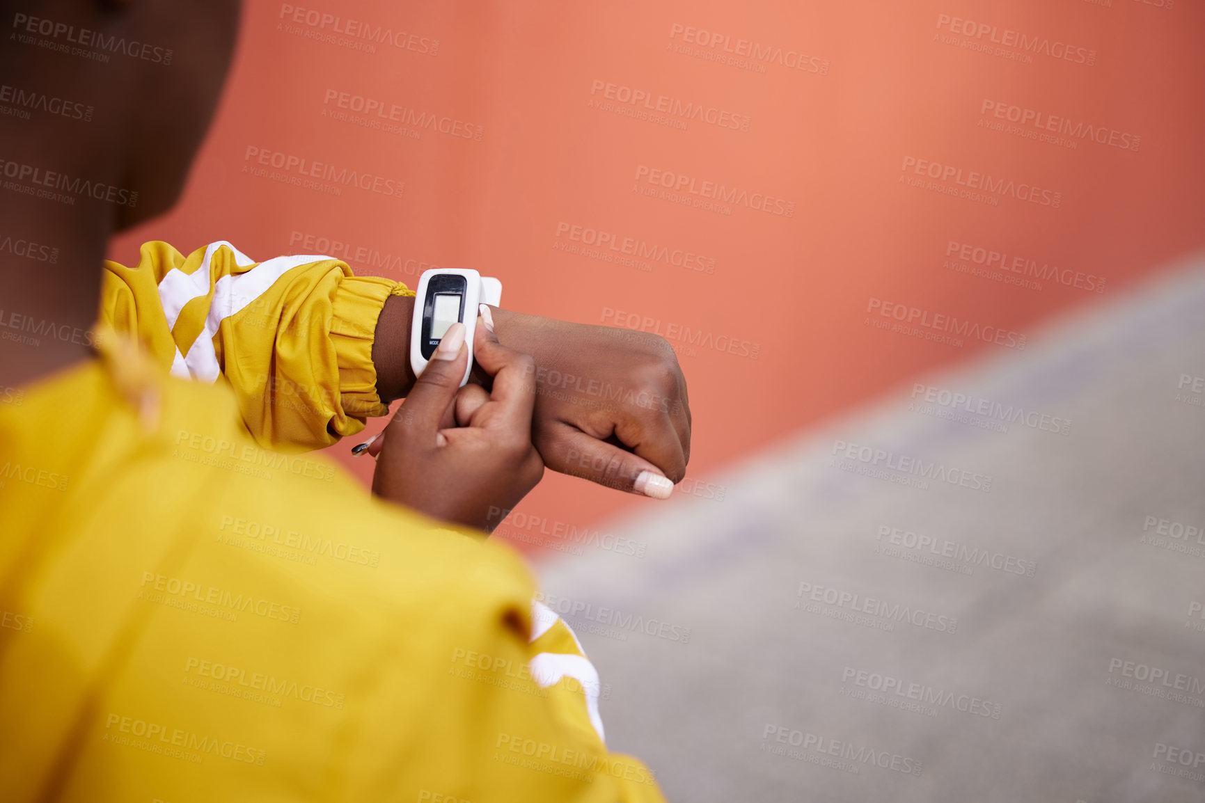 Buy stock photo Cropped shot of a woman checking her smartwatch during her work out against an urban background