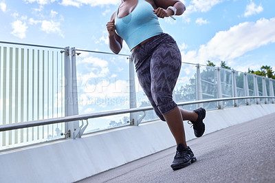 Buy stock photo Cropped shot of a woman running against an urban background
