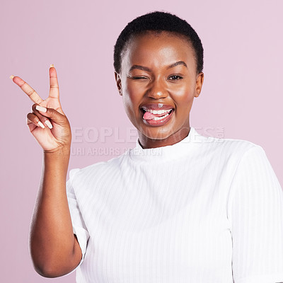 Buy stock photo Studio portrait of a young woman showing the peace sign against a pink background