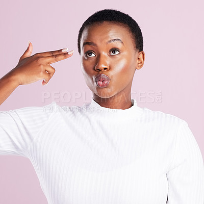 Buy stock photo Studio shot of a young woman holding up a finger gun gesture against a pink background