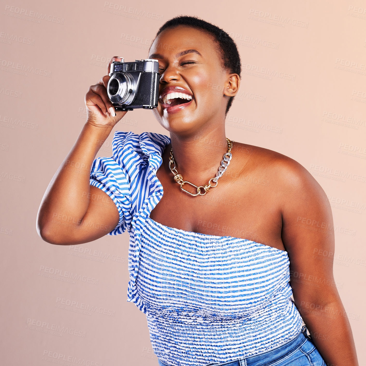 Buy stock photo Studio shot of a beautiful young woman using a camera against a oink background