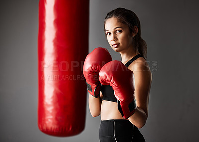 Buy stock photo Punching bag, boxer or portrait of woman in boxing training, exercise or workout in gym studio for wellness. Ready, female athlete or strong girl with confidence, fitness or power on grey background