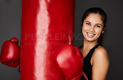 Buy stock photo Cropped portrait of an attractive young female boxer training in the gym