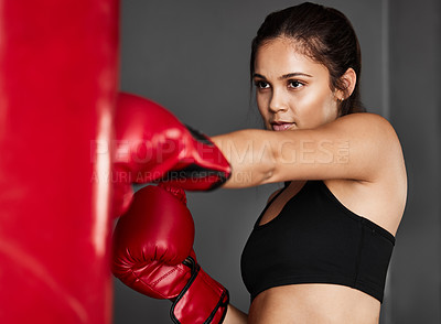 Buy stock photo Bag, boxer or woman punching in boxing training, exercise or workout in gym studio for wellness. Sports, female athlete or strong girl fighting with red gloves, fitness or power on grey background