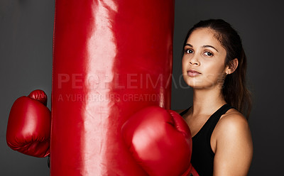 Buy stock photo Punching bag, boxer or portrait of girl in boxing training, exercise or workout in gym studio for wellness. Ready, female athlete or strong woman with confidence, fitness or power on grey background