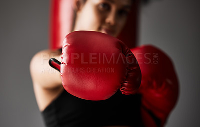 Buy stock photo Fist, boxer or woman punching in boxing training, exercise or workout in gym studio for wellness. Hand, sports athlete or strong girl fighting with red gloves, fitness or power on grey background