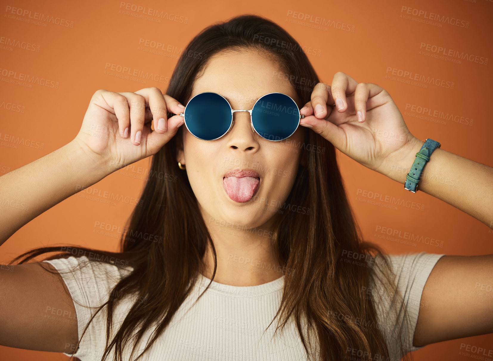 Buy stock photo Cropped portrait of an attractive young woman posing in studio against an orange background