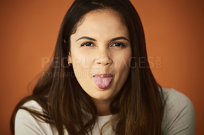 Buy stock photo Cropped portrait of an attractive young woman posing in studio against an orange background