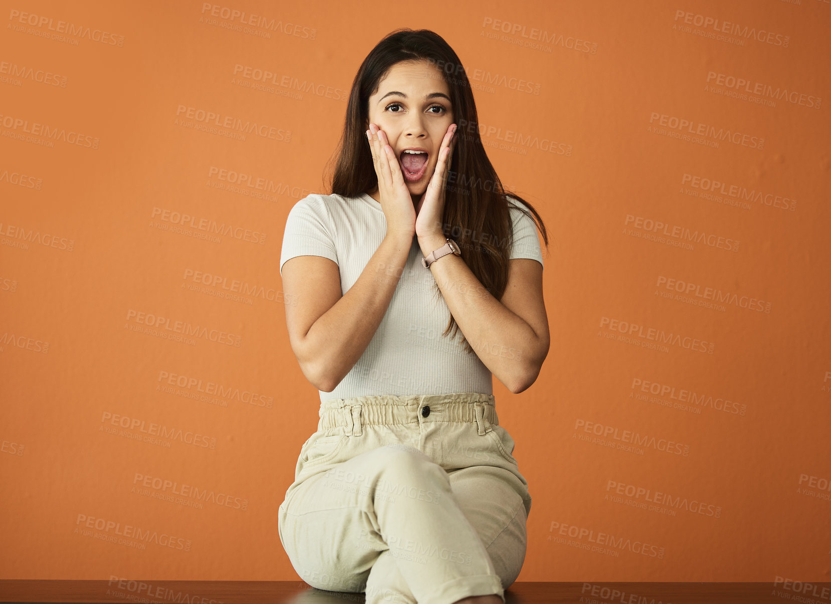 Buy stock photo Cropped portrait of an attractive young woman posing in studio against an orange background