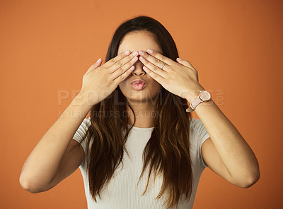 Buy stock photo Cropped shot of an attractive young woman posing in studio against an orange background