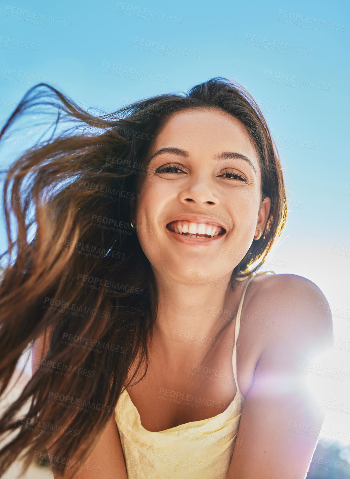 Buy stock photo Cropped portrait of an attractive young woman posing outside on a summer's day against the backdrop of a clear sky