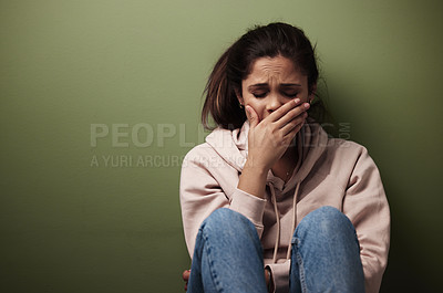 Buy stock photo Cropped shot of an attractive young woman crying against a green background