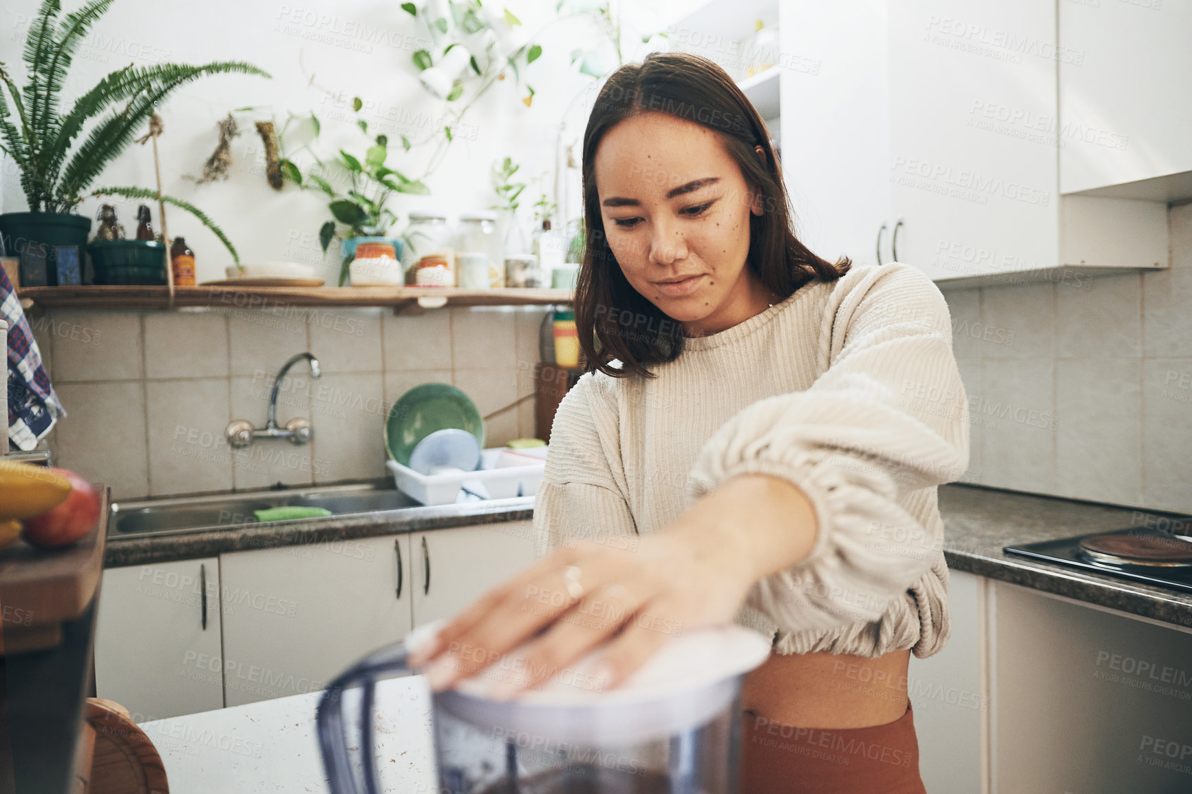 Buy stock photo Shot of a young woman using her blender to make a smoothie