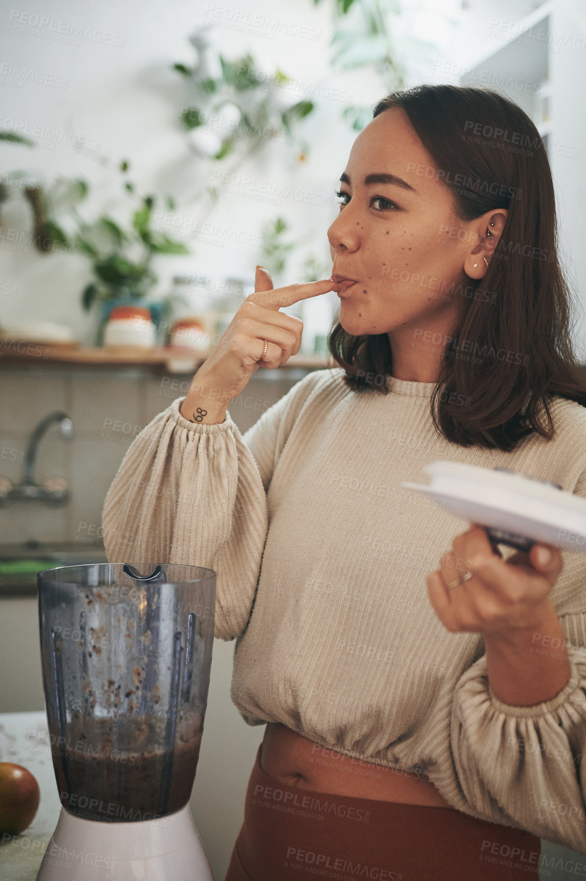 Buy stock photo Shot of a young woman tasting her smoothie